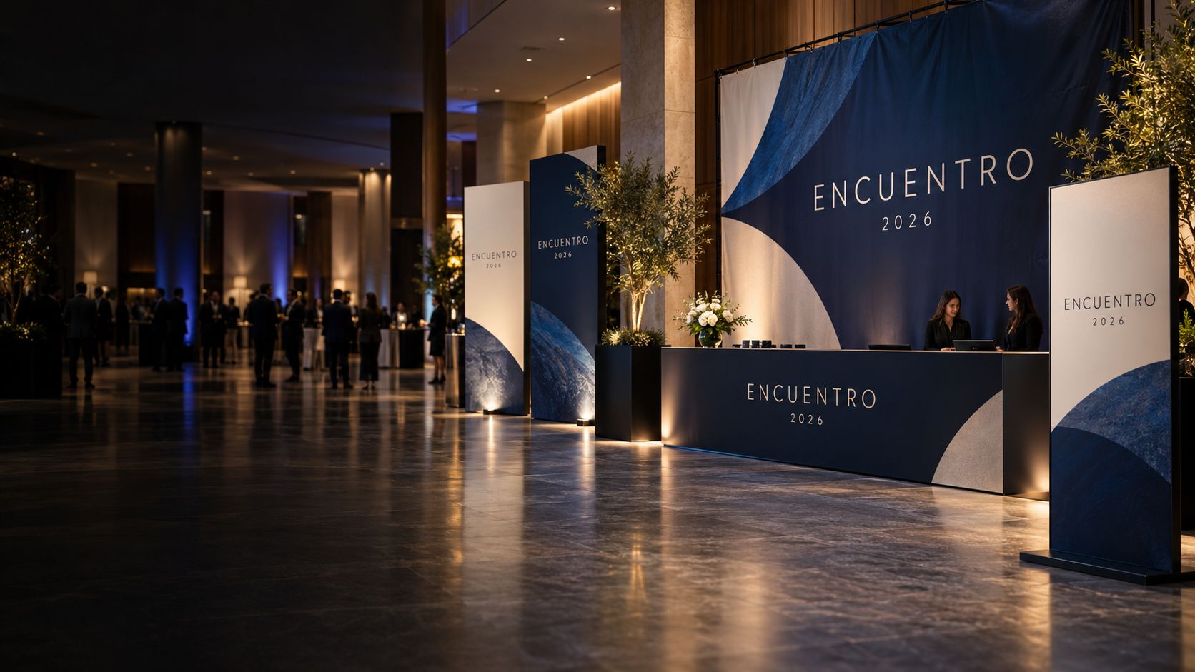 Hall de evento con backing, displays y mostrador de acreditación con la gráfica Encuentro 2026